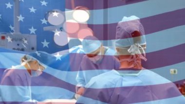 Maskeli cerrahların üzerinde sallanan Amerikan bayrağının animasyonu. küresel covid 19 salgın hastalık ve sağlık hizmetleri konsepti dijital olarak oluşturulmuş video.