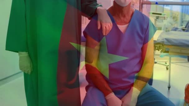 Анімація Прапора Камеруну Махає Над Хірургами Масках Обличчя Глобальна Концепція — стокове відео