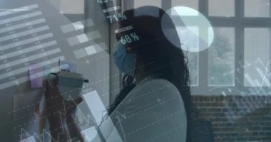 Yüz maskesi takan iş kadınının finansal veri işleme animasyonu. covid 19 salgın konsepti dijital olarak üretilen video konsepti sırasında küresel iş, finans, bağlantılar ve dijital arayüz.
