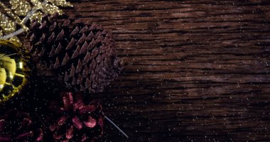 Yılbaşı çam kozalakları dekorasyonu ve tahtaya yağan karlar. Noel kutlaması konsepti dijital olarak oluşturulmuş görüntü.