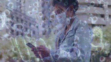 Yüz maskeli bir kadının üzerinde hareket eden kovid 19 hücrenin animasyonu. küresel covid 19 salgın hastalık ve sağlık hizmetleri konsepti dijital olarak oluşturulmuş video.