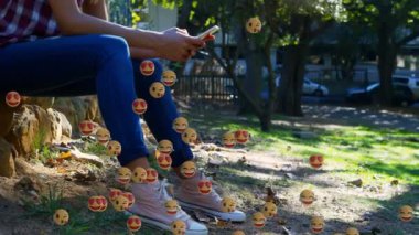 Kürsüde akıllı telefon kullanan bir kadın için düşen emojilerin animasyonu. küresel sosyal medya, dijital arayüz, teknoloji ve bağlantılar konsepti dijital olarak oluşturulmuş video.