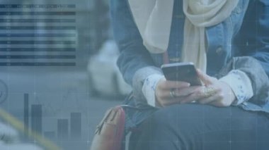 Akıllı telefon kullanan tesettürlü bir kadının finansal veri işleme animasyonu. küresel iş, finans, bağlantılar ve teknoloji konsepti dijital olarak oluşturulmuş video.