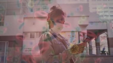 Yüz maskeli bir kadının üzerinde hareket eden kovid 19 hücrenin animasyonu. küresel covid 19 salgın hastalık ve sağlık hizmetleri konsepti dijital olarak oluşturulmuş video.