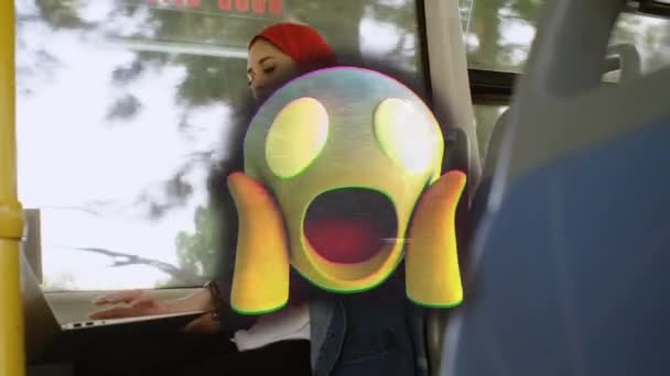 バスのラップトップを使用してヒジャーブの女性の上に怖い絵文字のアニメーション 世界中のソーシャルメディア デジタルインターフェース テクノロジーと接続の概念デジタルで生成されたビデオ — ストック動画