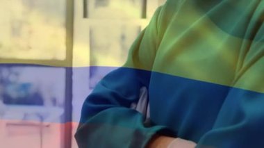 Yüz maskeli cerrahların üzerinde sallanan Kolombiya bayrağı animasyonu. küresel covid 19 salgın hastalık ve sağlık hizmetleri konsepti dijital olarak oluşturulmuş video.