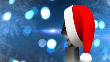 Noel Baba şapkası mikrofonda mavi arka plandaki ışık lekelerine karşı. Noel müziği ve kutlama konsepti
