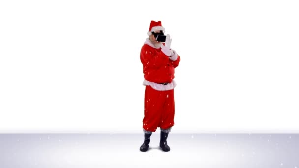 雪は灰色の背景に対してVrヘッドセットダンスを身に着けているサンタクラスの上に落ちます クリスマス フェスティバルとお祝いのコンセプト — ストック動画