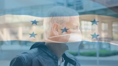 Covid 19 salgını sırasında yüz maskesi takan adamın üzerinde sallanan Honduras bayrağı animasyonu. küresel covid 19 salgın konsepti dijital olarak oluşturulmuş video.