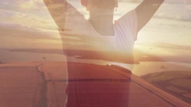 Kumsalda gerinen mutlu beyaz kadın ve gölün üzerinde gün batımının birleşimi. Sağlıklı emeklilik, zindelik ve refah konsepti dijital olarak oluşturulmuş video.