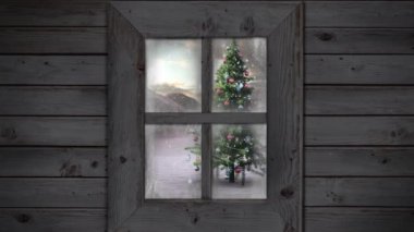 Kış manzarasında Noel ağacının üzerine düşen kara karşı ahşap pencere çerçevesi. Noel şenliği ve kutlama konsepti