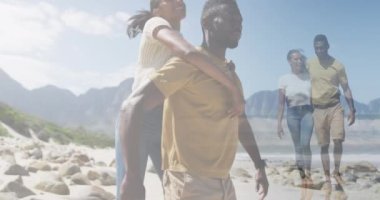 Mutlu Afrika kökenli Amerikalı çiftlerin birleşimi ve kumsalda yürürken kucaklaşmaları. sağlık, rahatlama, romantizm ve refah konsepti dijital olarak oluşturulmuş video.