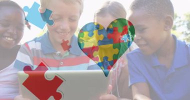 Tablet kullanan çocukların üzerindeki renkli yapboz parçalarının animasyonu. otizm, öğrenme güçlüğü, destek ve farkındalık kavramı dijital olarak oluşturulmuş video.