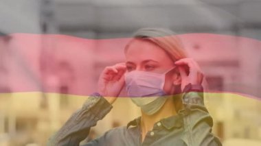 Covid 19 salgını sırasında yüzü maskeli bir kadının üzerinde sallanan Alman bayrağının animasyonu. küresel covid 19 salgın konsepti dijital olarak oluşturulmuş video.