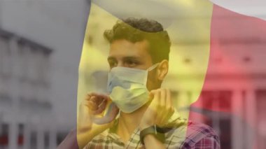 Covid 19 salgını sırasında yüz maskesi takan adamın üzerinde sallanan Belçika bayrağı animasyonu. küresel covid 19 salgın konsepti dijital olarak oluşturulmuş video.