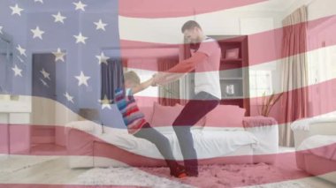 Amerikan bayrağının sallanışı mutlu beyaz baba ve oğulun oturma odasında oynaması. Amerikan vatanseverliği, bağımsızlık ve kutlama konsepti dijital olarak oluşturulmuş video.