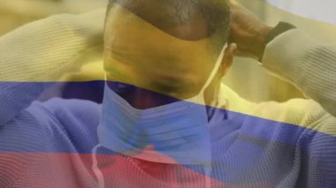 Covid 19 salgını sırasında yüz maskesi takan adamın üzerinde sallanan Kolombiya bayrağı animasyonu. küresel covid 19 salgın konsepti dijital olarak oluşturulmuş video.