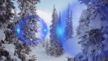 Kış manzarasında köknar ağaçlarının üzerinde mavi noel süslerinin canlandırılması. Noel, kış, gelenek ve kutlama konsepti dijital olarak oluşturulmuş video.