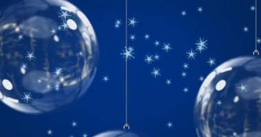 Mavi arka planda, Noel süslemeleri üzerine düşen kar animasyonu. Noel, kış, gelenek ve kutlama konsepti dijital olarak oluşturulmuş video.