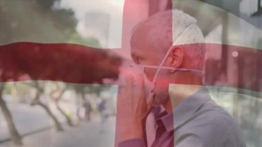 İngiltere bayrağının canlandırılması. Covid 19 salgını sırasında yüz maskesi takan adamın üzerinde sallanıyor. küresel covid 19 salgın konsepti dijital olarak oluşturulmuş video.