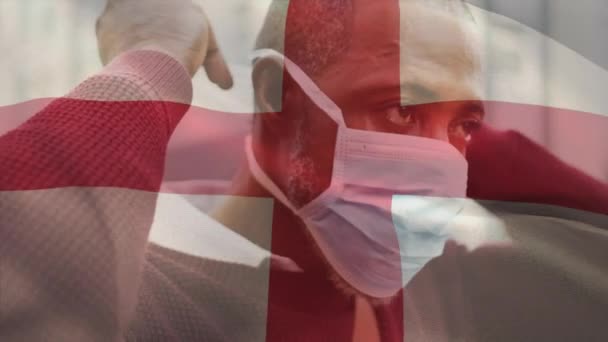 Animación Bandera Inglaterra Ondeando Sobre Hombre Con Máscara Facial Durante — Vídeo de stock