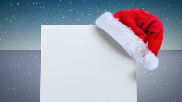 Chapéu Papai Noel Sobre Cartaz Branco Contra Neve Que Cai — Vídeo de Stock
