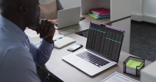 Afrikanischer Mann Sitzt Schreibtisch Und Beobachtet Die Verschlüsselung Der Datenverarbeitung — Stockvideo