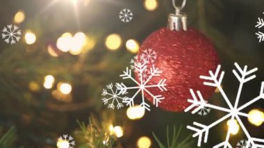 Kırmızı takı üzerine düşen kar taneleri ışık noktalarına asılıyor. Noel şenliği ve kutlama konsepti