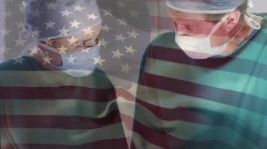 Ameliyathanede cerrahların üzerinde sallanan ABD bayrağının animasyonu. küresel tıp, covid 19 pandemik konsept sırasında sağlık hizmetleri dijital olarak üretilen video.