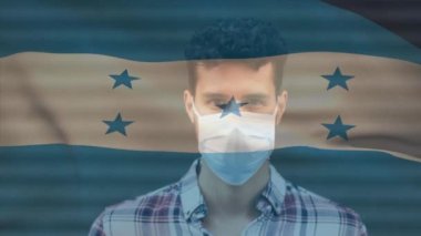 Covid 19 salgını sırasında yüz maskesi takan adamın üzerinde sallanan Honduras bayrağı animasyonu. küresel covid 19 salgın konsepti dijital olarak oluşturulmuş video.