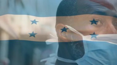 Covid 19 salgını sırasında yüz maskesi takan adamın üzerinde sallanan Honduras bayrağı animasyonu. küresel covid 19 salgın konsepti dijital olarak oluşturulmuş video.