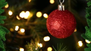 Kırmızı arka planda Noel ışıkları üzerine çam ağaçlarının canlandırılması. Noel, kış, gelenek ve kutlama konsepti dijital olarak oluşturulmuş video.