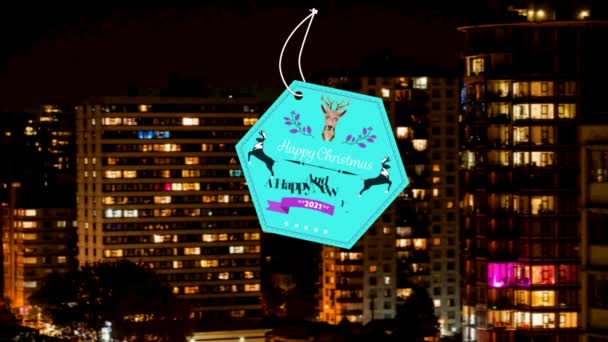 夜の街並みの空中風景に対する幸せなクリスマスと新年の青いテキストバナー クリスマス フェスティバルと新年の前夜祭のコンセプト — ストック動画