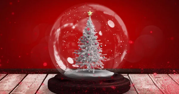 Immagine Albero Natale Sfera Neve Una Superficie Legno Sfondo Rosso — Foto Stock