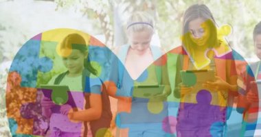 Renkli yapboz parçalarının animasyonu ve elektronik cihazlar kullanan çocuklar yerine kalp. otizm, öğrenme güçlüğü, destek ve farkındalık kavramı dijital olarak oluşturulmuş video.