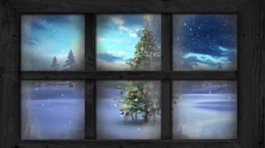 Kış manzarasında Noel ağacının üzerine düşen kara karşı ahşap pencere çerçevesi. Noel şenliği ve kutlama konsepti