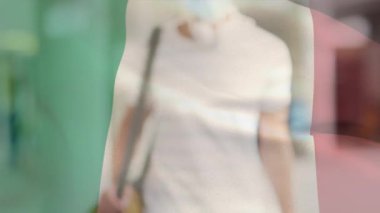 Covid 19 salgını sırasında maske takan adamın üzerinde sallanan İtalyan bayrağının animasyonu. küresel covid 19 salgın konsepti dijital olarak oluşturulmuş video.