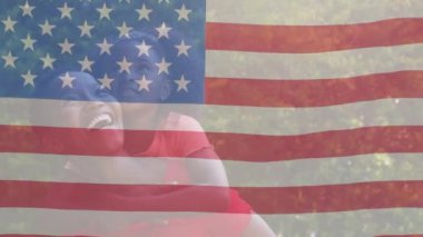 Amerika bayrağının Afro-Amerikan kadın ve kızının üzerinde dalgalanması. Amerikan vatanseverliği, bağımsızlık ve kutlama konsepti dijital olarak oluşturulmuş video.
