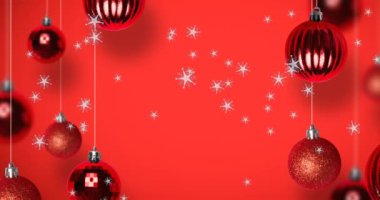 Kırmızı arka planda, Noel süslemeleri üzerine düşen kar animasyonu. Noel, kış, gelenek ve kutlama konsepti dijital olarak oluşturulmuş video.