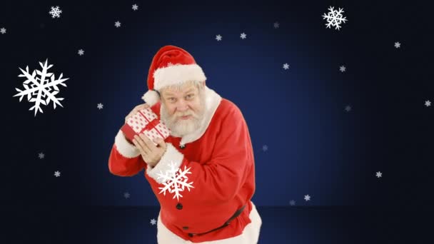Animace Santa Claus Držení Dárek Sněhem Padající Přes Modré Pozadí — Stock video