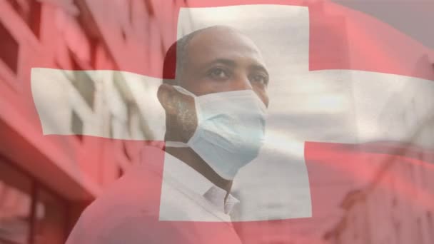 Animace Vlajky Švýcarska Vlnící Nad Mužem Obličejovou Maskou Během Covid — Stock video