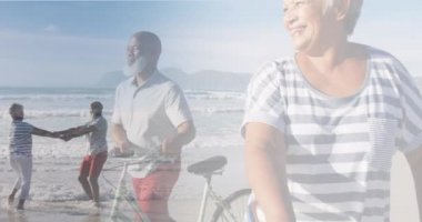 Bisikletle yürüyen ve plajda dans eden mutlu yaşlı çiftin birleşimi. Sağlıklı emeklilik, spor, eğlence ve refah konsepti dijital olarak oluşturulmuş video.