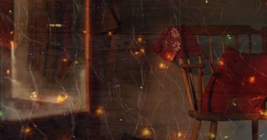 Renkli peri ışıklarının dijital kompozisyonu evdeki ahşap sandalyede Noel beresine karşı. Noel kutlaması geleneği