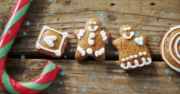 圣诞节姜饼人饼干和糖果手杖的图片 上面的木片上飘落着雪花 圣诞庆祝概念数字生成的图像 — 图库照片