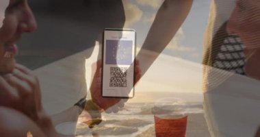 Sahilde el ele tutuşan çifte karşı ekranda QR kodlu bir akıllı telefonu tutan kadın. covid-19 aşı sertifikası ve sağlık kartı konsepti
