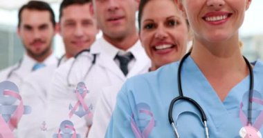 Pembe kurdele ve çapa logolarının animasyonu, gülümseyen bir grup kadın ve erkek doktorun üzerinde yüzüyor. Göğüs kanseri pozitif kadın sağlığı bilinçlendirme kampanyası konsepti dijital olarak üretilen video.