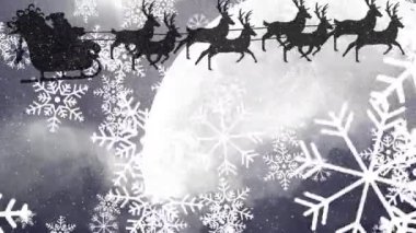 Noel Baba 'nın üzerine düşen kar taneleri gece gökyüzünde ren geyikleri tarafından çekiliyor. Noel şenliği ve kutlama konsepti