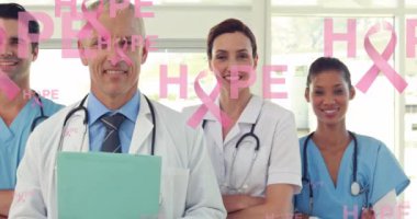 Gülümseyen erkek ve kadın doktorların üzerinde yüzen pembe kurdele logolu umut metninin animasyonu. Göğüs kanseri pozitif kadın sağlığı bilinçlendirme kampanyası konsepti dijital olarak üretilen video.