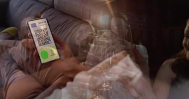 Ekranda QR kodlu bir akıllı telefonu tutan bir kadın içki içen bir grup arkadaşa karşı. covid-19 aşı sertifikası ve sağlık kartı konsepti