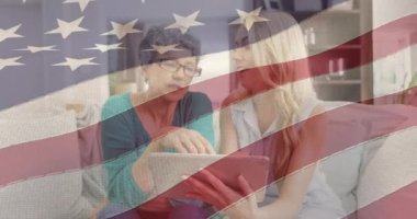 Amerikan bayrağının evdeki tablet kullanılarak anne ve kızının üzerinde canlandırılması. Vatanseverlik ve kutlama konsepti dijital olarak oluşturulmuş video.
